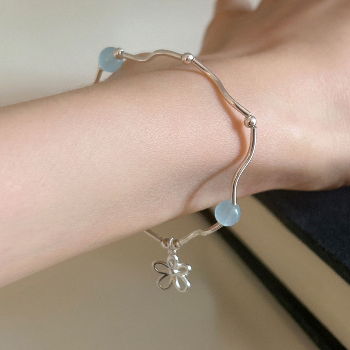 The wave-shaped round bead bracelet has a natural charm and an S-shaped curved tube